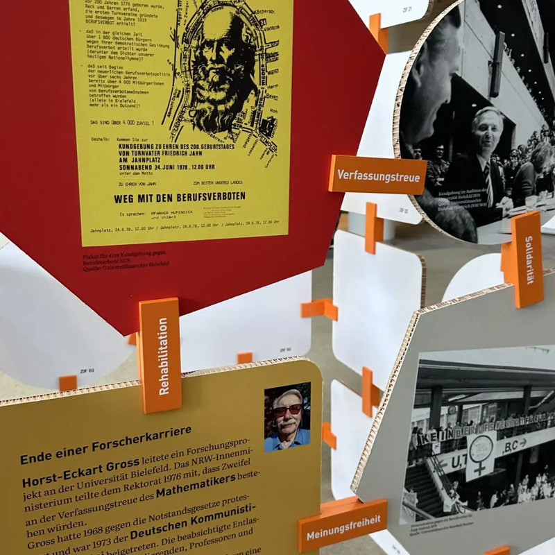 Installation aus miteinander verbundenen bunten geometrischen Formen. Darauf befinden sich Fotos und Texte zu Forschungsfreiheit, Verfassungstreue und Meinungsfreiheit.